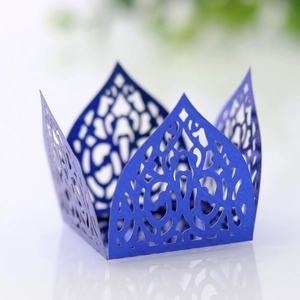 Macro detail of laser-cut dark blue paper cupcake wrappers with intricate lace patterns