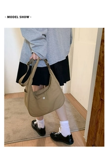 Présentation d'un sac demi-lune en nylon kaki avec bandoulière réglable sur modèle