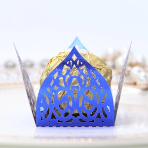 Close-up of laser-cut dark blue chocolate wrapper with vine lace pattern for parties
