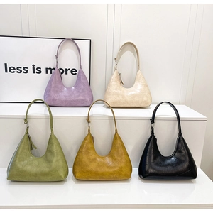 Collection of hobo underarm bags in five colors displayed on minimalist white stairs