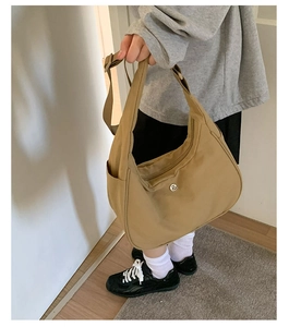 Détail du sac bandoulière en nylon kaki avec poche latérale et fermeture éclair