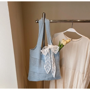 Détail du sac fourre-tout au crochet bleu clair avec nœud en dentelle et motif ajouré