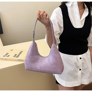 Detailed macro view of the purple crocodile texture on a stylish leather hobo armpit bag