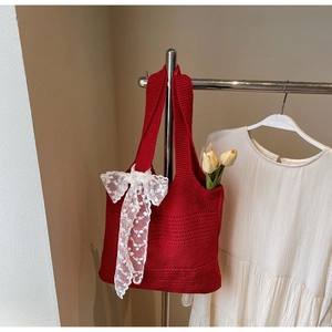 Détail du sac cabas en crochet rouge avec nœud en dentelle blanche et texture tressée