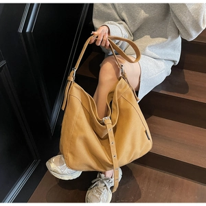 Macro shot of khaki canvas hobo bag with adjustable wide strap and silver metal buckle