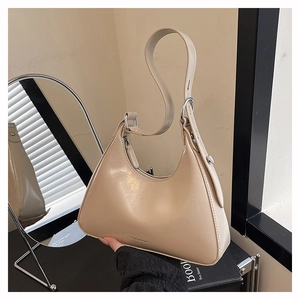 Detail of beige hobo bag showing adjustable strap and silver-tone hardware accents