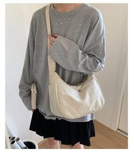 Détail du sac bandoulière croissant en nylon beige minimaliste avec sangle réglable porté