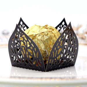 Macro detail of laser-cut vine patterns on black chocolate wrapper for parties