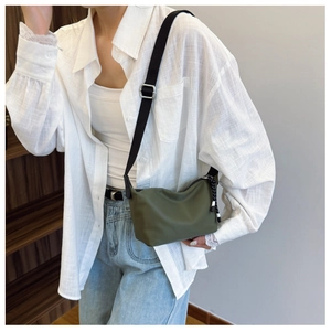 Detail of army green nylon dumpling bag showing adjustable strap and texture on model