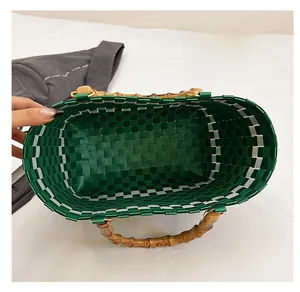 Vue de dessus de l'intérieur spacieux et des poignées en bambou du sac tressé vert