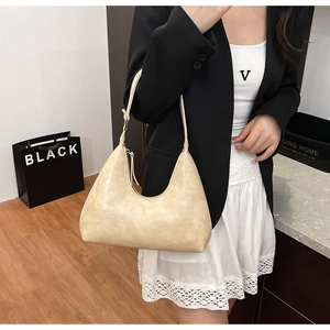 Chic beige leather hobo bag styled with a professional suit for a modern urban look