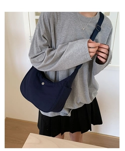Sac bandoulière en nylon bleu foncé avec logo métallique rond et sangle réglable