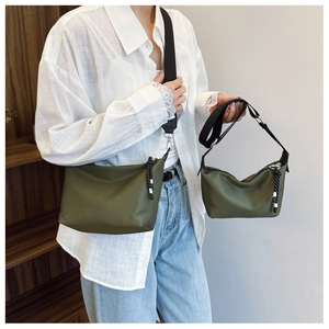 Comparison of large and small olive green nylon crossbody bags shown on model