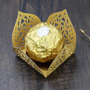 Detail of laser-cut gold lace favor box for chocolate with intricate floral hollow design