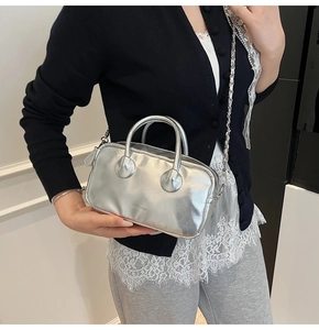 Detail of silver metallic handbag showing smooth finish and silver chain shoulder strap