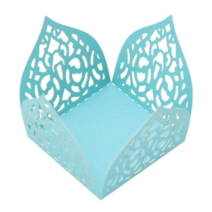 Macro detail of laser-cut light blue floral patterns on paper wedding favor box