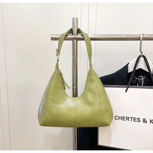 Detail of light green crocodile embossed texture on a chic minimalist hobo shoulder bag