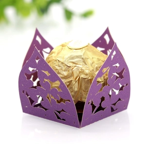 Detail einer lila lasergeschnittenen Bonbonschachtel mit goldener Praline innen
