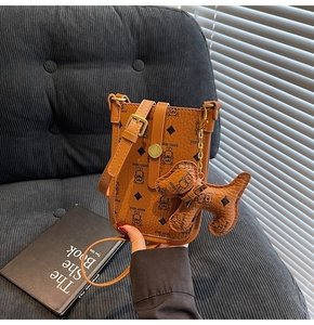 Detailed view of brown lychee leather mobile phone crossbody bag with cartoon bear and charm