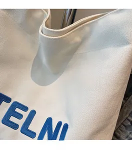 Dettaglio della borsa in tela con ricamo blu TELNI e trama in twill di alta qualità