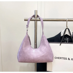 Detailed close-up of light purple hobo bag with crocodile pattern on a shop display