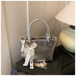 Silver pleated tote bag detail with pearl lace bow and adjustable shoulder strap