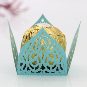 Close-up of laser-cut light blue candy box with elegant floral patterns and gold chocolate