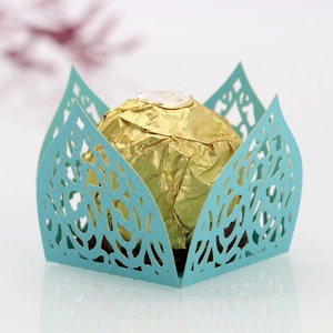 Close-up of laser cut light blue paper lace wrapper for single chocolate truffles