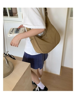Détail d'un sac hobo en nylon kaki avec bandoulière large et poche latérale de rangement