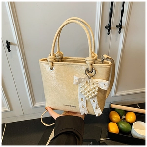 Detail of cream pleated bucket bag with pearl lace bow and brand logo MIAOSHE BAGS