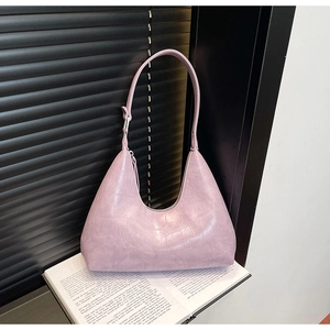 Detail of lavender hobo bag featuring croc-embossed texture on an open magazine