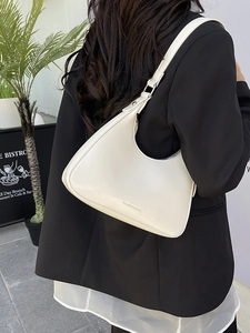 Minimalist creamy white hobo underarm bag with adjustable strap in a stylish street view