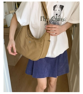 Détail du sac demi-lune en nylon kaki avec poche latérale et large bandoulière tissée