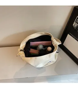 Vista interna della spaziosa borsa tote in tela bianca con grande capacità e fodera