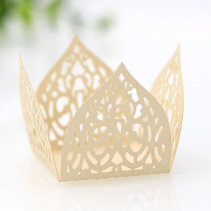 Macro shot of laser-cut cream paper cupcake wrappers with intricate hollow patterns