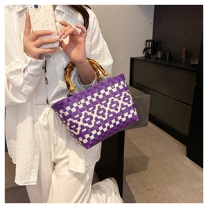 Détail du sac seau tressé violet et blanc avec une poignée en bambou naturel élégante