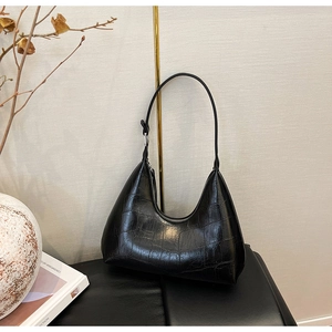 Detail of black faux crocodile skin texture on a stylish minimalist hobo shoulder bag