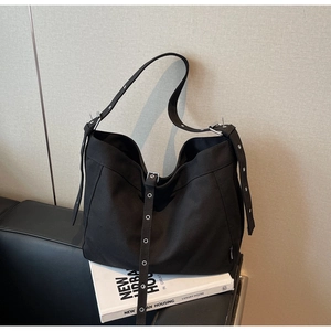 Detailed macro shot of vintage black canvas tote bag with silver metal eyelet straps