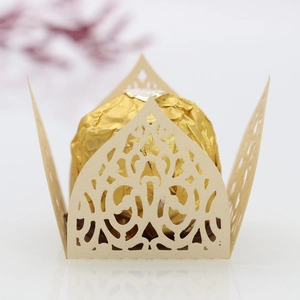 Macro shot of laser-cut champagne gold hollow candy box with ornate floral texture