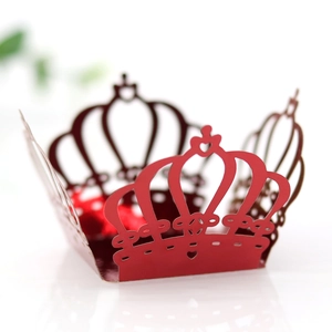 Macro shot of laser-cut red paper crown cupcake wrappers with heart details