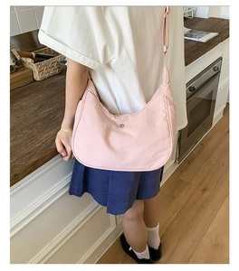 Détail du sac croissant en nylon rose avec bandoulière réglable et logo métal