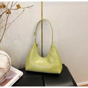 Detail of light green hobo bag featuring crocodile embossed texture and zipper closure
