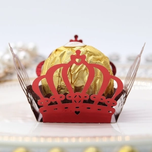 Macro shot of laser-cut red crown paper wrapper for chocolate and cupcake decoration