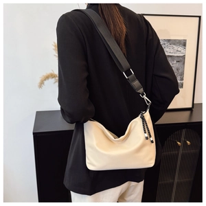 Detailed back view of a beige minimalist dumpling crossbody bag with wide black strap