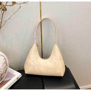 Detail view of cream-colored crocodile pattern hobo bag with sleek silver hardware buckle