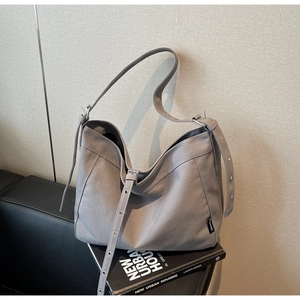Detail of adjustable wide shoulder strap on grey canvas tote bag with woven texture