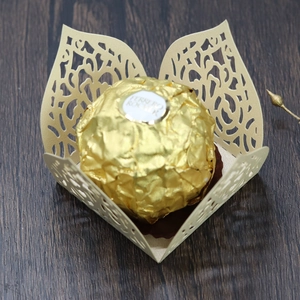 Macro view of laser-cut floral paper chocolate wrapper with elegant golden finish