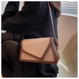 Detail view of the asymmetric crocodile-embossed flap and contrast color stitching