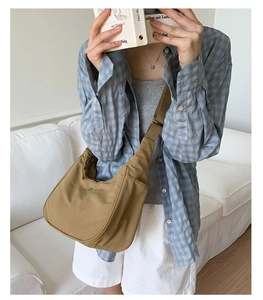 Sac bandoulière demi-lune en nylon kaki porté par un mannequin pour référence de style