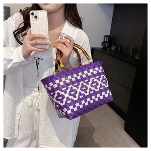 Détail du sac cabas tissé à la main avec poignée en bambou naturel et motif géométrique chic